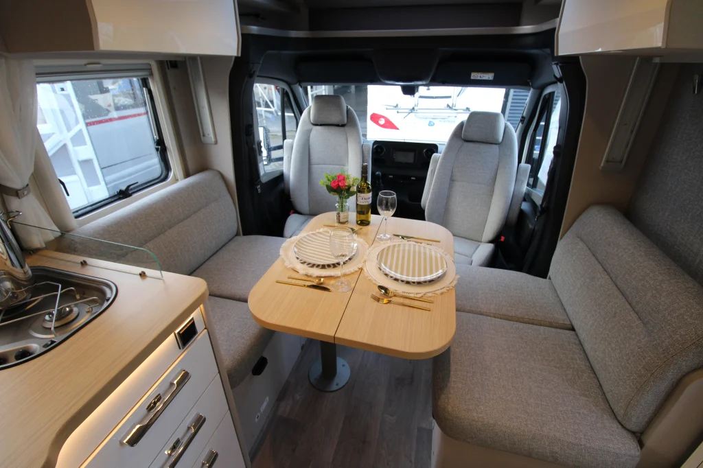 Hymer Tramp T 695 S zithoek met gedekte tafel en gedraaide cabinestoelen